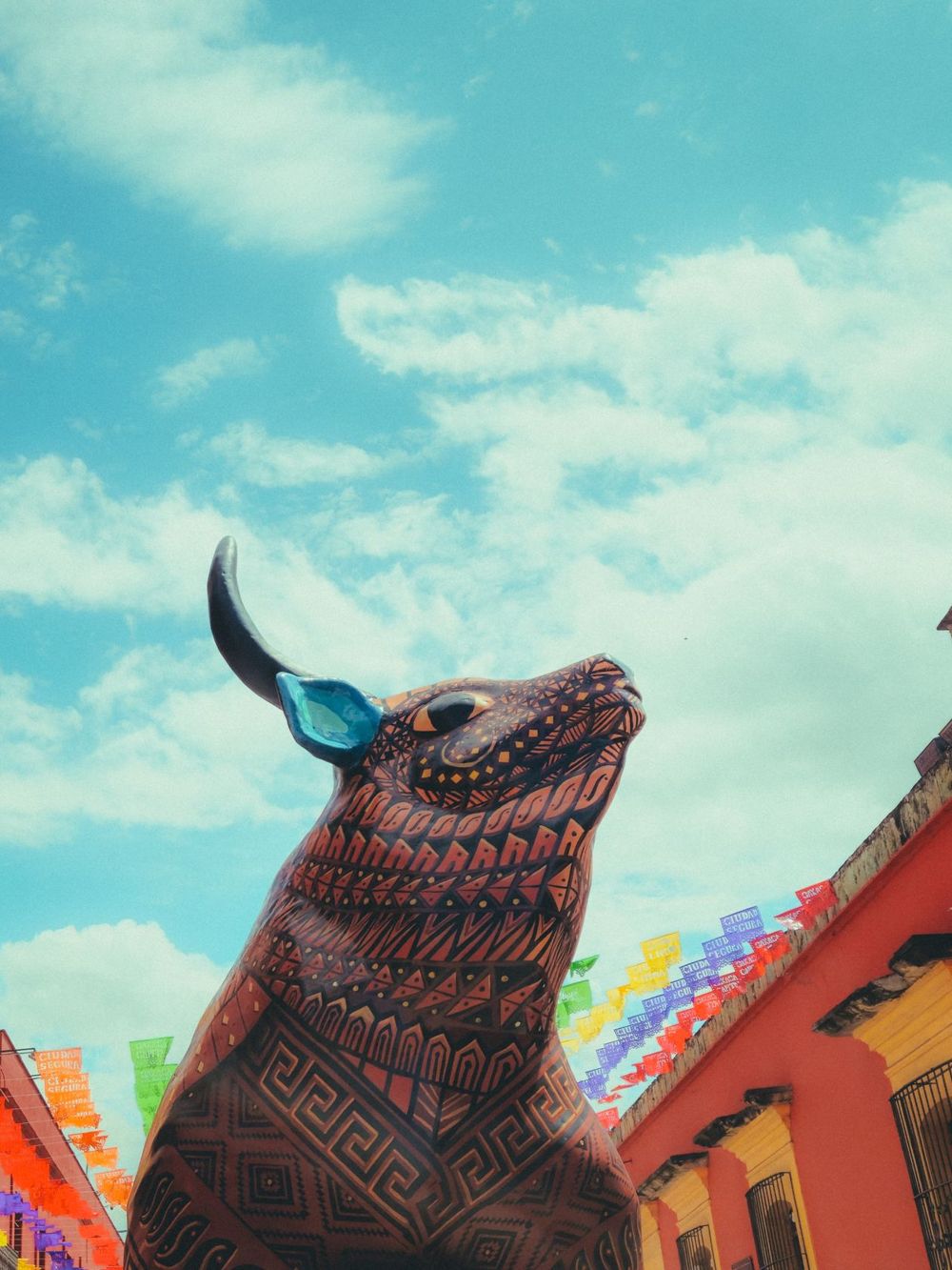 A decorated bull sculpture on a colorful Oaxaca street