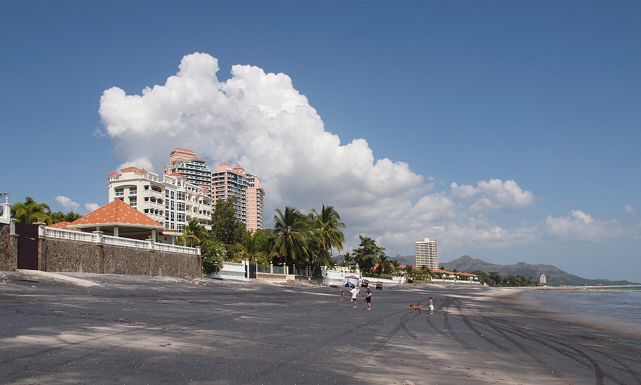 Dark-sand beach and condo towers at Playa Coronado